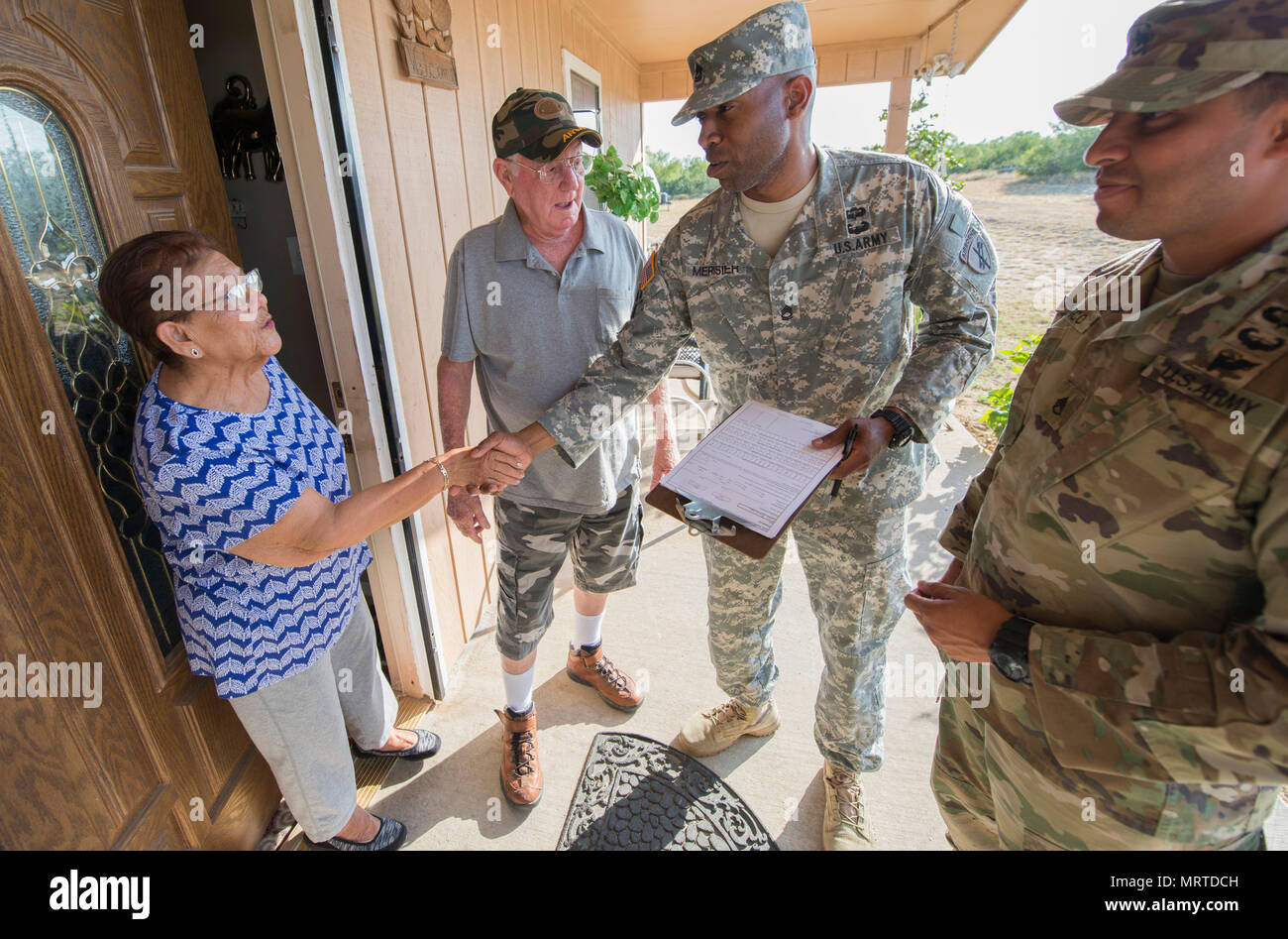 Sgt. 1st Class Rhody Merisier, middle right, and Staff Sgt. Aldo Blanco, both assigned to the 478th Civil Affairs Battalion based in Miami, conduct a survey with residents of a colonia currently without potable water near Laredo, Texas, June 23, 2017. Nearly 200 Reserve Soldiers are participating in an Innovative Readiness Training mission to improve infrastructures in colonias along the Texas-Mexico border. (Photo Credit: Sean Kimmons) Stock Photo