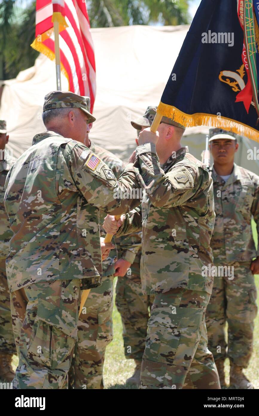 Lt. Col. Matthew L. Cloud (right), a native of Illinois, receives the battalion colors for the 100th Inf. Bn. from Col. Joseph A. Ricciardi (left), commander, 303rd Maneuver Enhancement Brigade, and reviewing officer of ceremony, during a change of command ceremony, June 22, at Fort Shafter Flats, U.S. Army Reserve Daniel K. Inouye Complex. Cloud received command of the battalion from outgoing commander Lt. Col. Kenneth Tafao. Stock Photo
