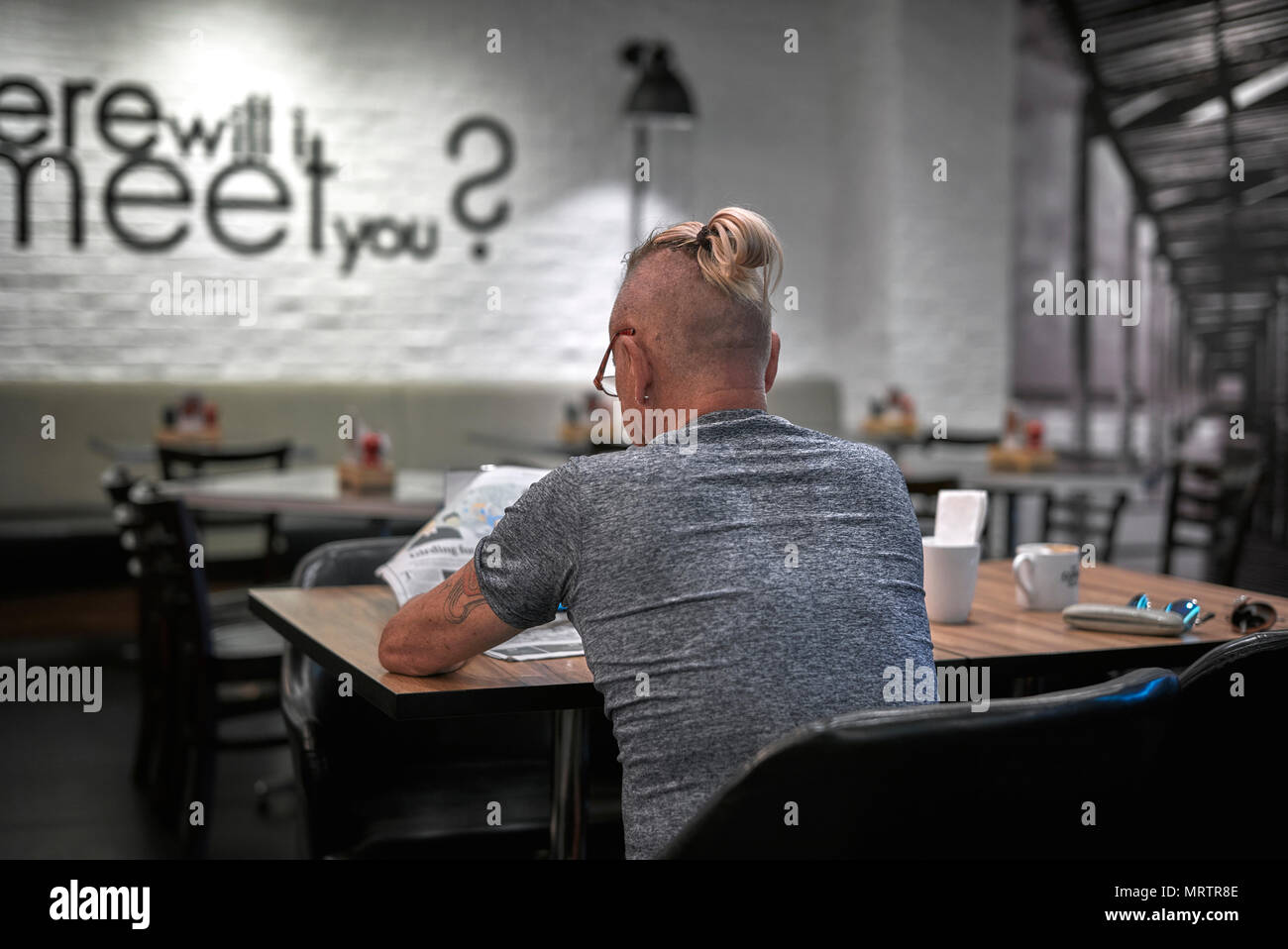 Man sporting top knot with shaven head and tied up ponytail hairstyle. Stock Photo