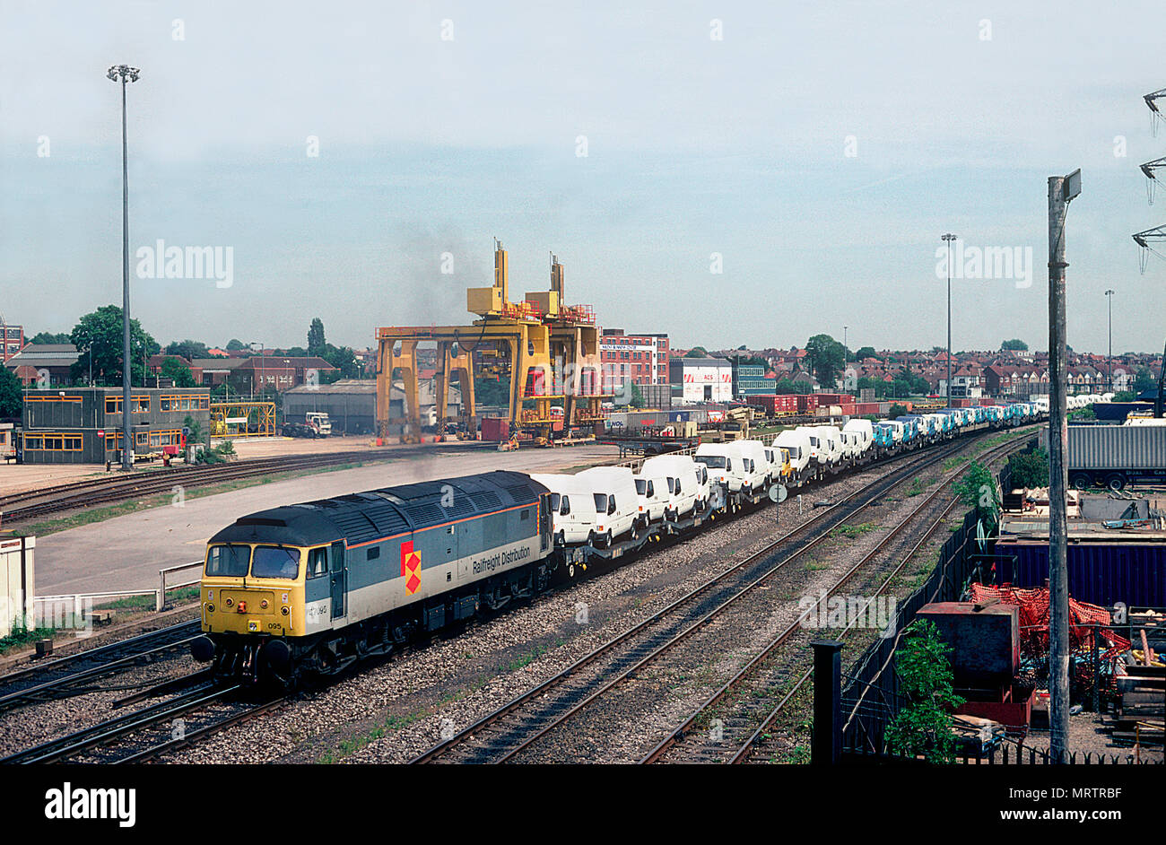 A class 47 diesel locomotive number 47095 with a freight train loaded with Ford vans passing Millbrook in Southampton on the 15th June 1996. Stock Photo