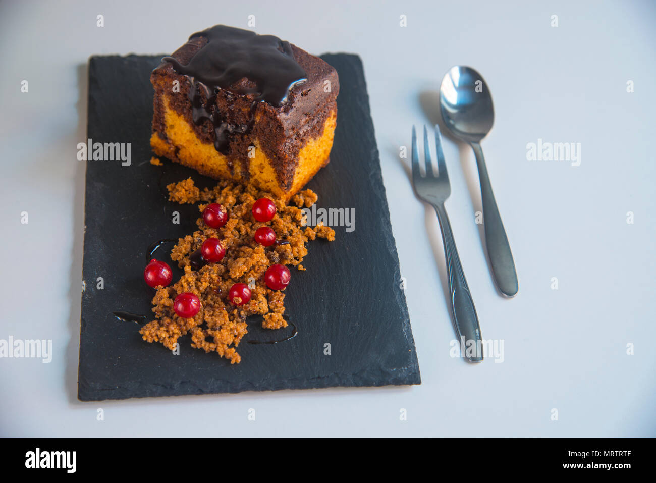 Marble cake with chocolate sauce and redcurrants. Stock Photo
