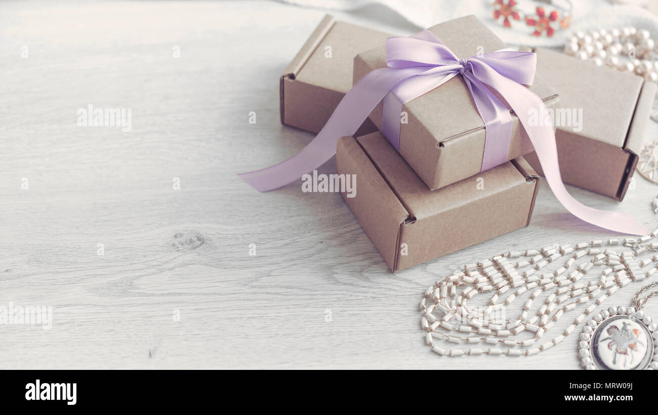 Decorative composition in retro style set of boxes with gifts. Crafting boxes on wooden background. Women's jewelry earring necklace bracelet Stock Photo