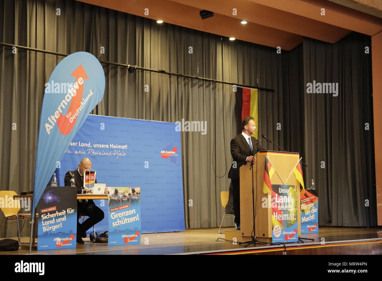 Jockgrim, Germany. 26th May, 2018. The parliamentary secretary of the AfD party in the Landtag (parliament) of Rhineland-Palatinate Jan Bollinger speaks on the podium. The parliamentary group of the right-wing populist AfD (Alternative for Germany) party of Rhineland-Palatinate celebrated the 2nd anniversary of their entry into the Rhineland-Palatinate state parliament in the 2016 state election in the South Palatinate city of Jockgrim. A counter-protest was organised by several groups outside the venue. Credit: Michael Debets/Pacific Pres/Alamy Live News Stock Photo