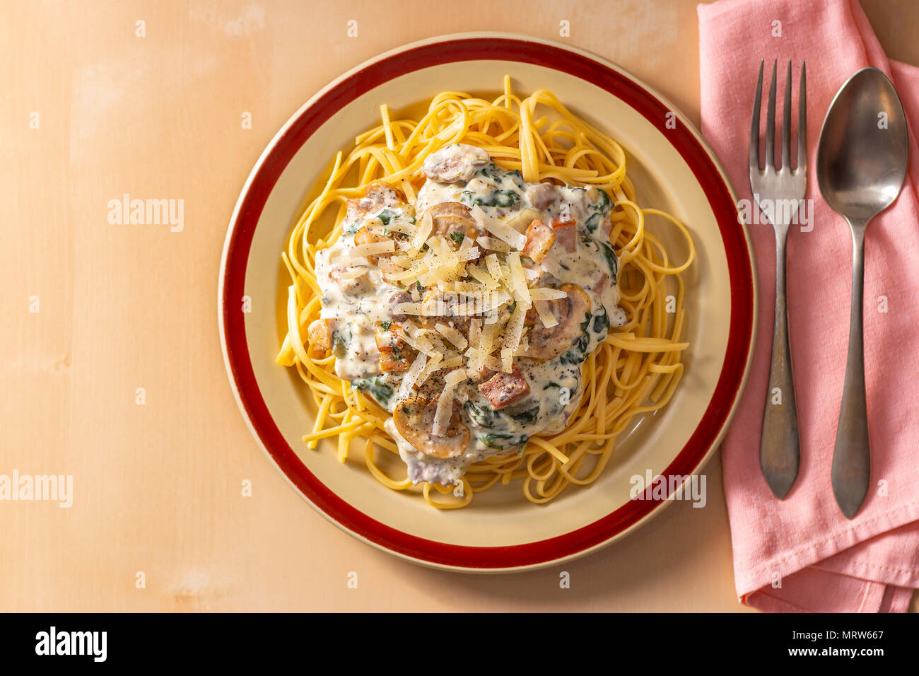 From above shot of served delicious Italian pasta with creamy sauce and mushrooms on table Stock Photo
