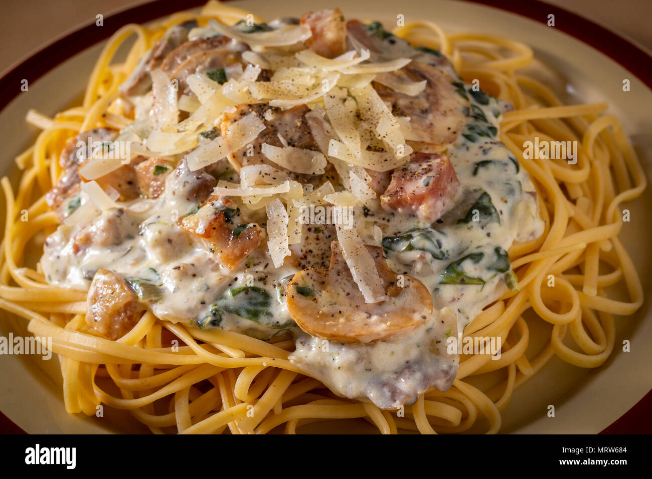 Close-up shot of spaghetti topped with creamy mushroom sauce, beacon and grated cheese Stock Photo