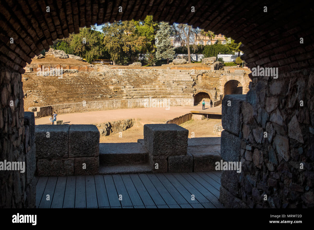 Merida, Spain - Oct 28, 2017: Arch and unrecognizable people walking on ruins of Roman Amphitheater of Merida in sunny day in Merida, Spain on October 28, 2017 Stock Photo