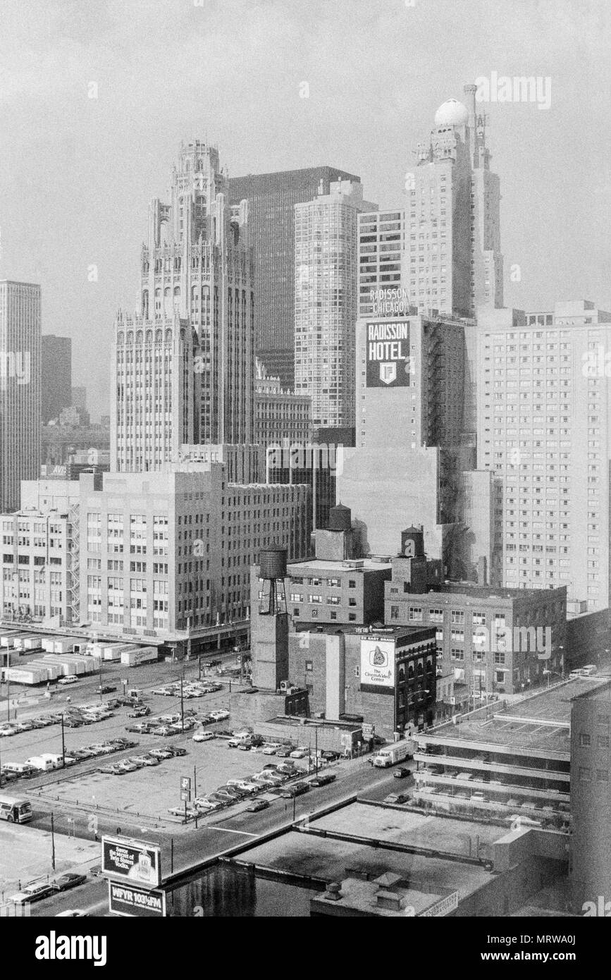 Black and white view of Chicago in 1980. The Radisson Chicago hotel in the centre, as well as a sign for 211 East Grand, an advert for Twin Sisters Vodka, and and advert for WFYR Radio station. Stock Photo