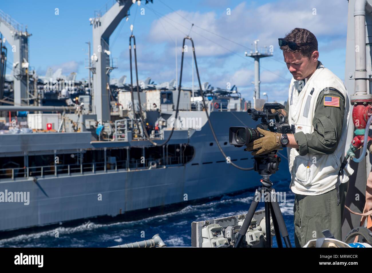 170622-N-VR594-0468 PACIFIC OCEAN (June 22, 2017) Lt. Joseph Cusick, from Yorba Linda, Calif., records footage of the Ticonderoga-class guided-missile cruiser USS Princeton (CG 59) conducting a replenishment-at-sea with the fleet replenishment oiler USNS Yukon (T-AO 202). Princeton is currently deployed in the 7th fleet area of operations. The U.S. Navy has patrolled the Indo-Asia-Pacific routinely for more than 70 years promoting regional peace and security. (U.S. Navy photo by Mass Communication Specialist 3rd Class Kelsey J. Hockenberger/Released) Stock Photo