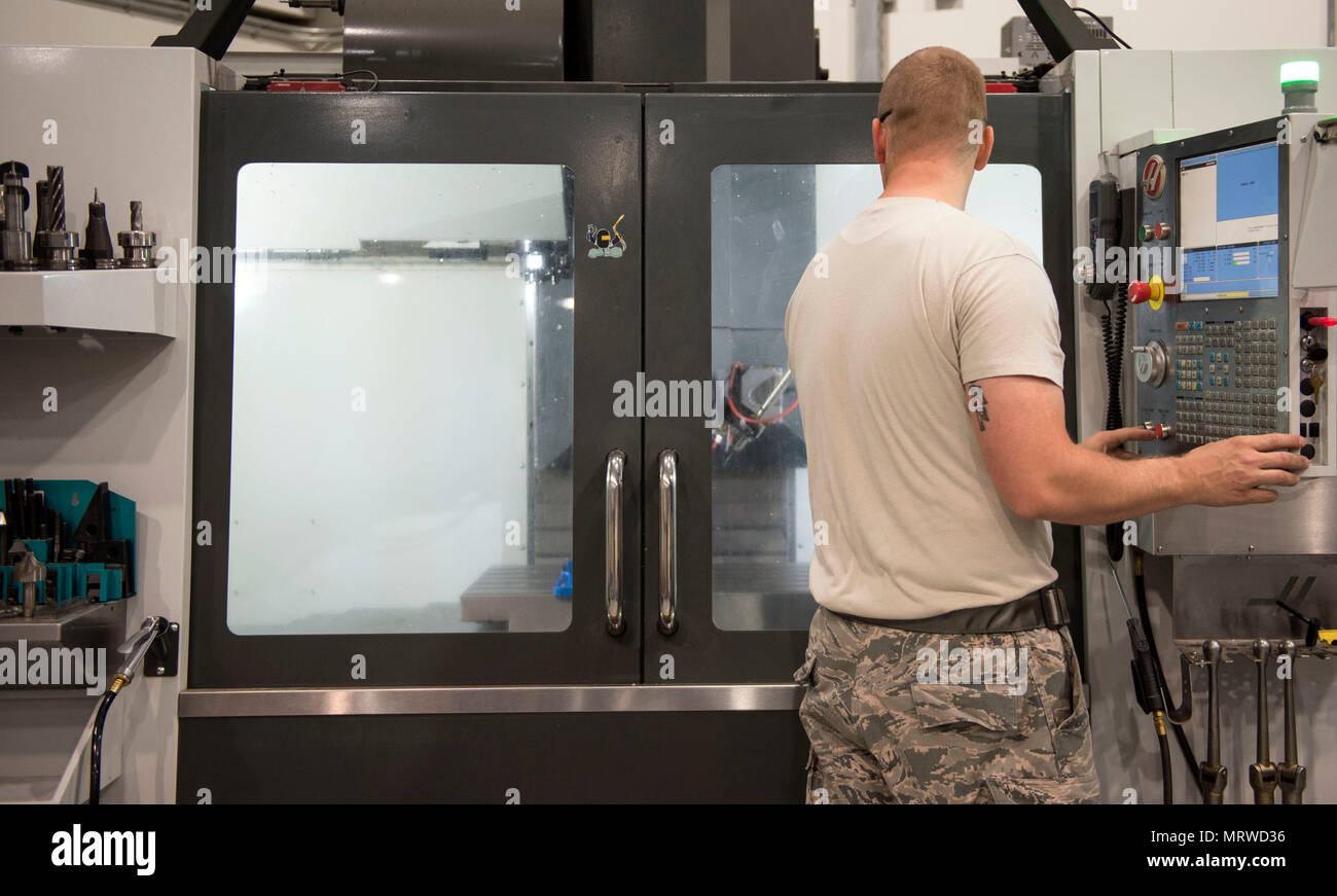 U.S. Air Force Staff Andrew Walker, a fabrication specialist with the 379th Expeditionary Maintenance Squadron uses a computer numerical control machine at Al Udeid Air Base, Qatar, June 5, 2017. The CNC allows Walker and other machinists to increase the speed of the manufacturing and reduce the wait time for new aircraft parts. (U.S. Air Force photo by Tech. Sgt. Amy M. Lovgren) Stock Photo
