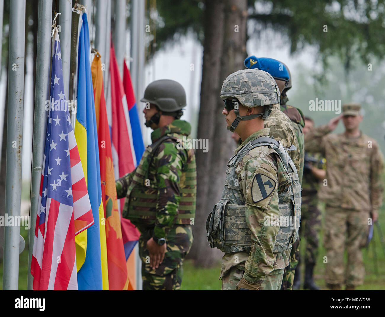 Soldiers from Armenia, Croatia, Montenegro, Romania, Ukraine and the United States wait to raise their nation’s flag during the official opening ceremony for the multinational training exercise Getica Saber 17 at Joint National Training Center in Cincu, Romania, July 7, 2017. Getica Saber 17 is a U.S-led fire support coordination exercise and combined arms live-fire exercise that incorporates six Allied and partner nations with more than 4,000 Soldiers. Getica Saber runs concurrent with Saber Guardian, a U.S. Army Europe-led, multinational exercise that spans across Bulgaria, Hungary and Roman Stock Photo