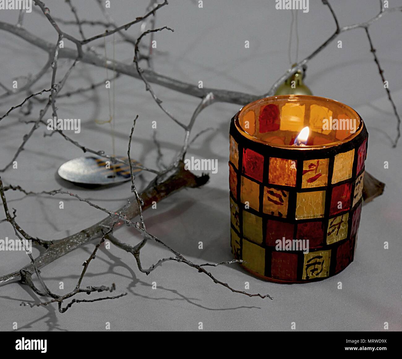 A candle burning inside a colorful artistically designed glass Stock Photo Alamy