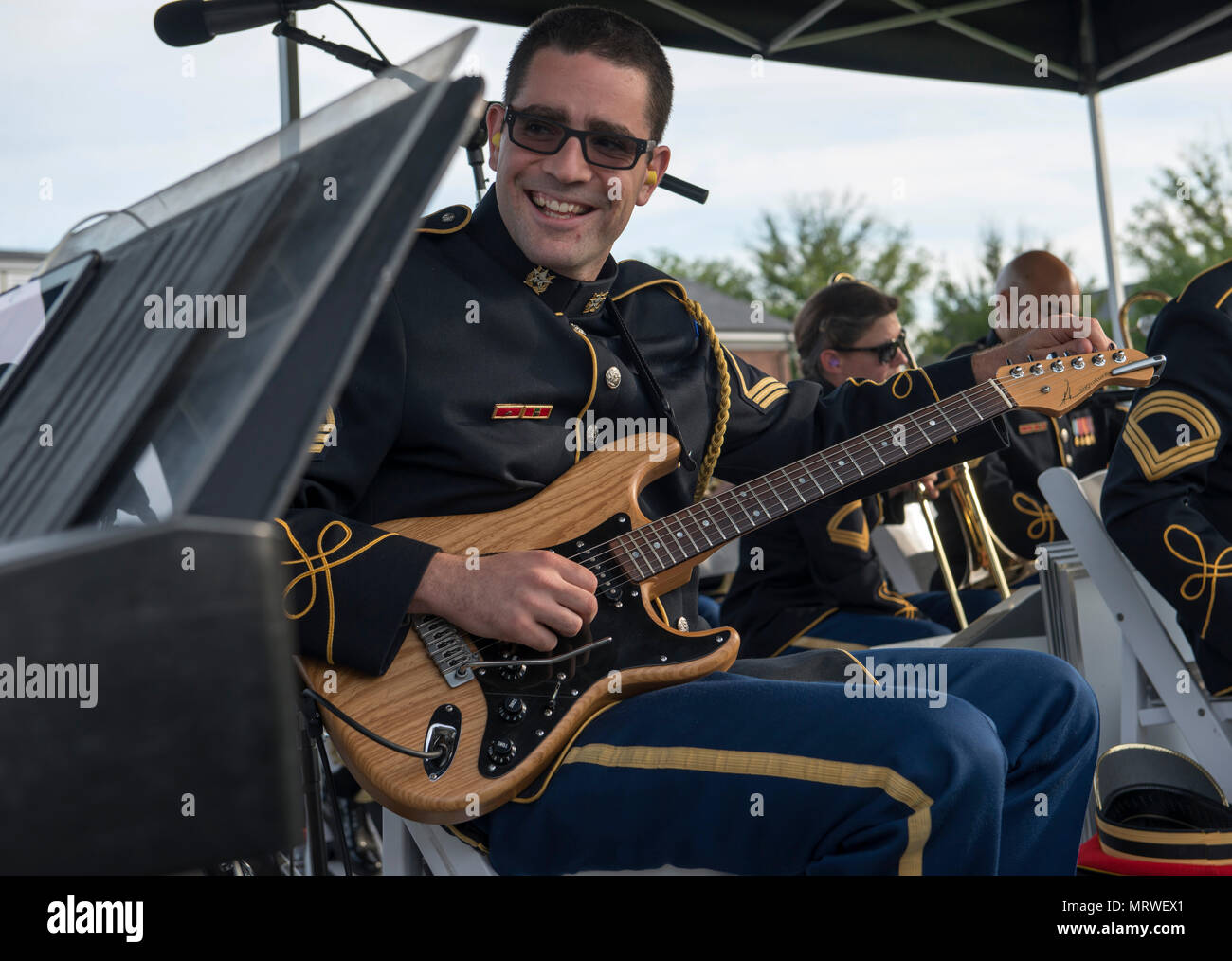 Staff Sgt. Michael G. Kramer, U.S. Army Blues Ensemble, The U.S. Army Band “Pershing’s Own,” tunes his guitar prior to the next musical selection during Twilight Tattoo, June 28, 2017, on Summerall Field, Joint Base Myer-Henderson Hall, Va. Twilight Tattoo is an hour-long, live-action military performance featuring performances by Soldiers from the 3d U.S. Infantry Regiment (The Old Guard) and The U.S. Army Band 'Pershing's Own.” (U.S. Army photo by Staff Sgt. Austin L. Thomas) Stock Photo