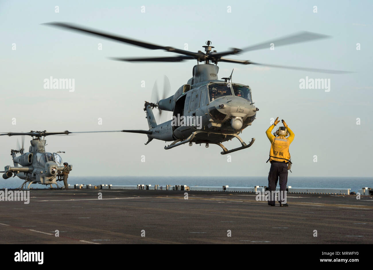 170706-N-LI768-898    PACIFIC OCEAN (July 6, 2017) Aviation Boatswain’s Mate (Handling) 3rd Class Drake Valdiviezo, from Lehi, Utah, signals for a UH-1Y Huey, assigned to the “Gunfighters” of Marine Light Attack Helicopter Squadron (HMLA) 369, to take off from the flight deck of the amphibious assault ship USS Makin Island (LHD 8). Makin Island is conducting operations off the coast of Southern California. (U.S. Navy photo by Mass Communication Specialist 2nd Class Devin M. Langer) Stock Photo