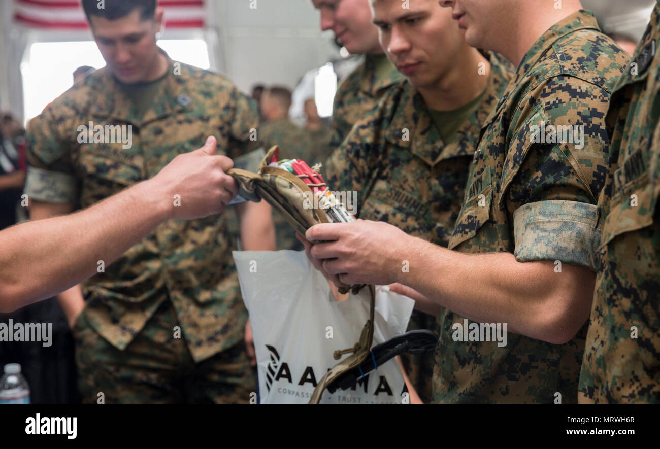 U.S. Marines and Sailors familiarize themselves with new first aid kits during the Marine South Military Exposition, Goettege Field House, Camp Lejeune N.C., April 13, 2017. The Marine South Exposition is sponsored by the Marine Corps League and is a forum for defense contractors to display, inform, and promote the latest in defense equipment and technology. Stock Photo