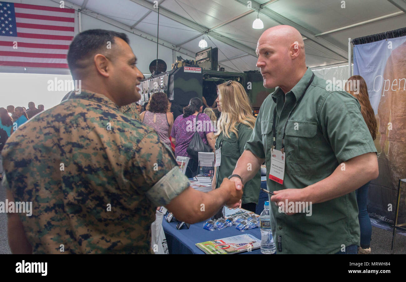 Retired Sgt. Maj. of the Marine Corps, Michael P. Barrett, shakes hands with a Marine at the Marine South Military Exposition, Goettege Field House, Camp Lejeune N.C., April 13, 2017. The Marine South Exposition is sponsored by the Marine Corps League and is a forum for defense contractors to display, inform, and promote the latest in defense equipment and technology. Stock Photo