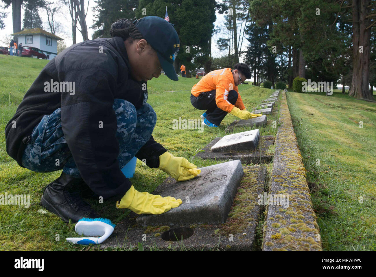 Washington (April 14, 2017) Logistics Specialist 2nd Class Jailyn Powell from Sylacauga, Alabama, and Culinary Specialist 2nd Class Jamillah Williams from Forest, Mississippi, both assigned to USS John C. Stennis (CVN 74), clean headstones at Ivy Green Cemetery during a community service event. John C. Stennis is conducting a planned incremental availability (PIA) at Puget Sound Naval Shipyard and Intermediate Maintenance Facility, during which the ship is undergoing scheduled maintenance and upgrades. Stock Photo