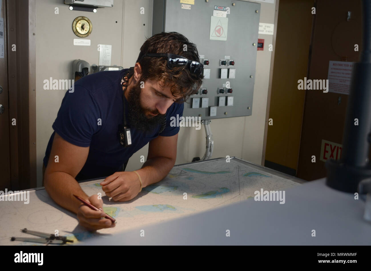 170711-N-WJ640-015 NOUMEA, New Caledonia (July 11, 2017) Aaron Caputo, Navigator/Operator aboard USNS Sacagawea (T-AKE 2), charts a course during sea and anchor detail for the ships outboard journey from New Caledonia during Koa Moana 17, July 11. Koa Moana 17 is designed to improve theater security, and conduct aw enforcement and infantry training in the Pacific region in order to enhance interoperability with partner nations. (U.S. Navy photo by Mass Communication Specialist 3rd Class Madailein Abbott) Stock Photo