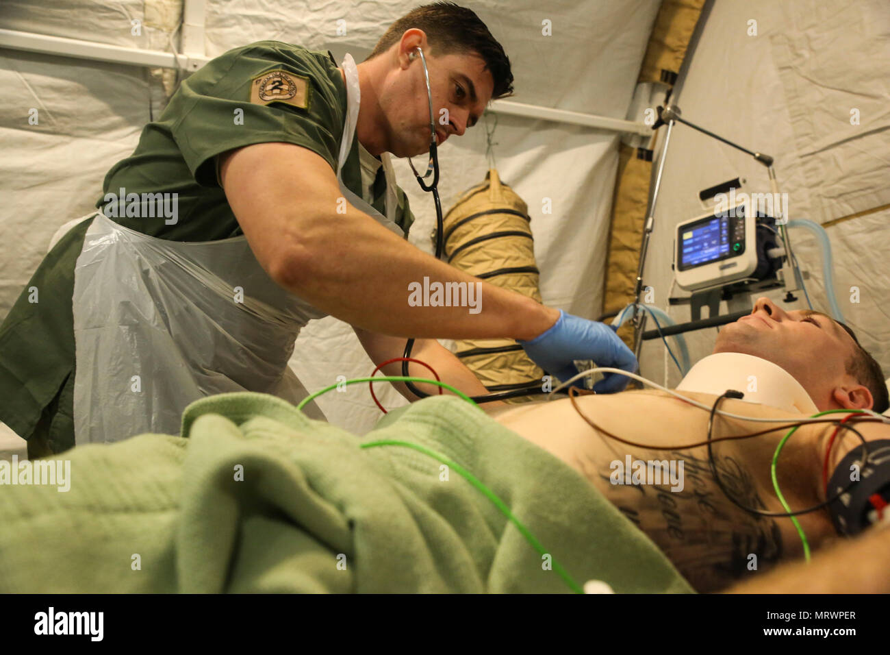 Corporal James Gummow, a medic with 2nd General Health Battalion, 17th Combat Service Support Brigade, evaluates a patient with a simulated sternum fracture during a mass casualty exercise at Williamson Air Field, Shoalwater Bay Training Area, Queensland, Australia, July 8, 2017 during Talisman Saber 17. Australian Army soldiers with 17th CSS Brigade conducted a mass-casualty exercise at Williamson Air Field hospital to practice Role 2 advanced trauma care and procedures that are used in a deployed environment. Exercises like Talisman Saber provide effective and intense training to ensure our  Stock Photo