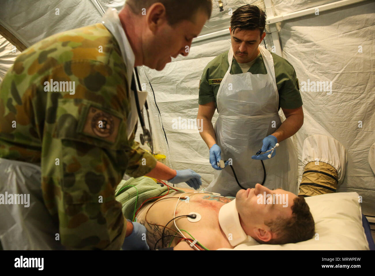 Major Paddy Bates, a trauma nurse with 3rd Health Support Battalion, 17th Combat Service Support Brigade, and Corporal James Gummow, a medic with 2nd General Health Battalion, 17th CSS Brigade, evaluate a patient with a simulated sternum fracture during a mass casualty exercise at Williamson Air Field, Shoalwater Bay Training Area, Queensland, Australia, July 8, 2017 during Talisman Saber 17. Australian Army soldiers with 17th CSS Brigade conducted a mass-casualty exercise at Williamson Air Field hospital to practice Role 2 advanced trauma care and procedures that are used in a deployed enviro Stock Photo