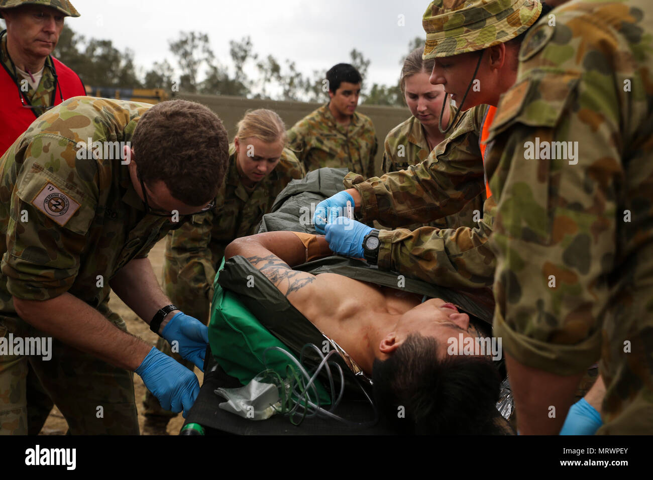 Australian Army medics with 17th Combat Service Support Brigade evaluate a patient with a simulated gunshot wound during a mass casualty exercise at Williamson Air Field, Shoalwater Bay Training Area, Queensland, Australia, July 8, 2017 during Talisman Saber 17. Soldiers with 17th CSS Brigade conducted a mass-casualty exercise at Williamson Air Field hospital to practice Role 2 advanced trauma care and procedures that are used in a deployed environment. Exercises like Talisman Saber provide effective and intense training to ensure our forces are capable, interoperable, deployable on short noti Stock Photo