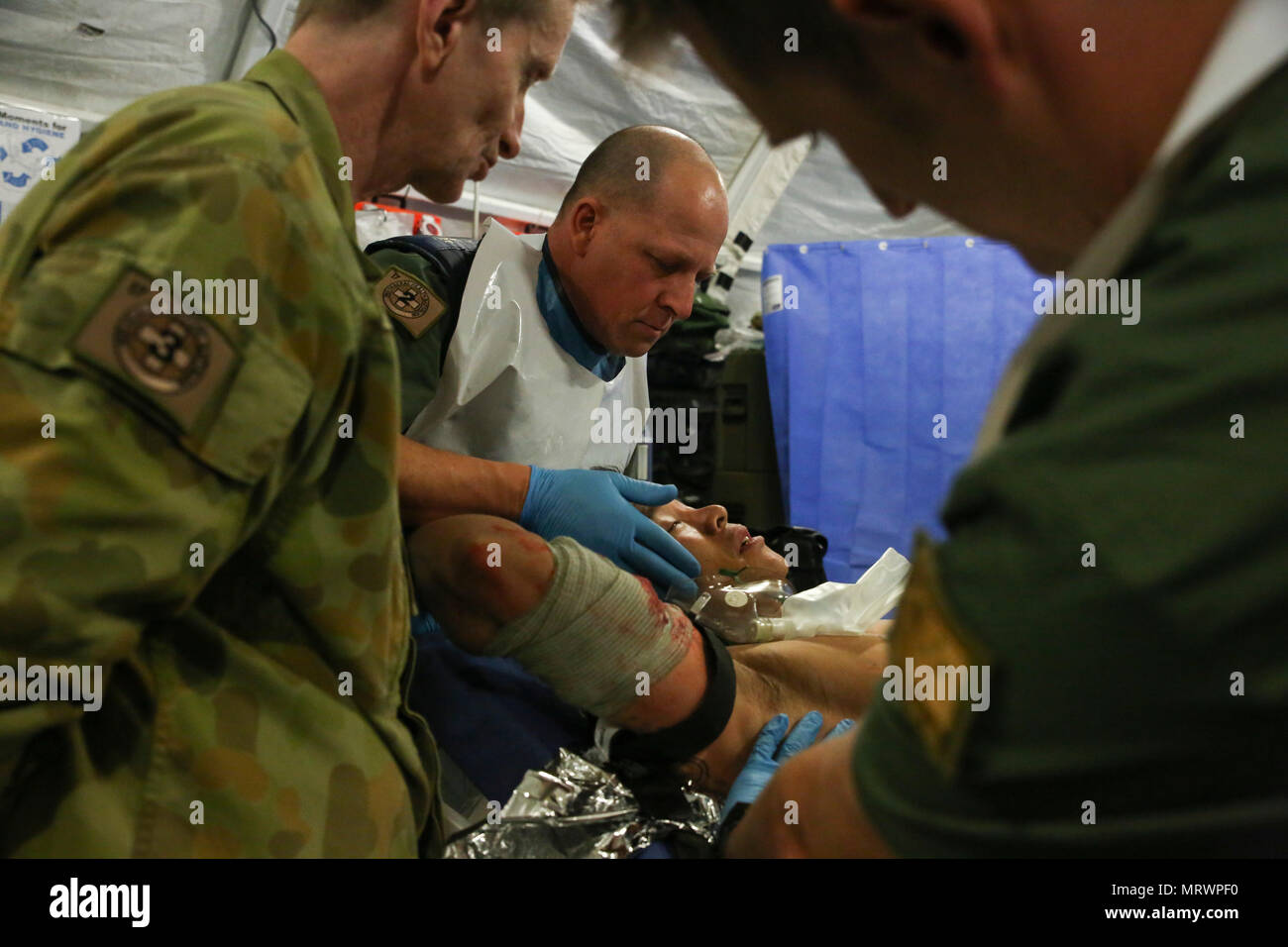 Australian Army medics with 17th Combat Service Support Brigade evaluate a patient with a simulated gunshot wound during a mass casualty exercise at Williamson Air Field, Shoalwater Bay Training Area, Queensland, Australia, July 8, 2017 during Talisman Saber 17. Soldiers with 17th CSS Brigade conducted a mass-casualty exercise at Williamson Air Field hospital to practice Role 2 advanced trauma care and procedures that are used in a deployed environment. Exercises like Talisman Saber provide effective and intense training to ensure our forces are capable, interoperable, deployable on short noti Stock Photo