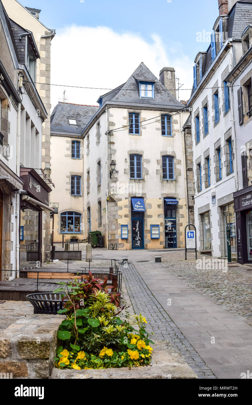 Walking up a pretty street filled with lovely stone buildings in Quimper, Brittany, France. Stock Photo