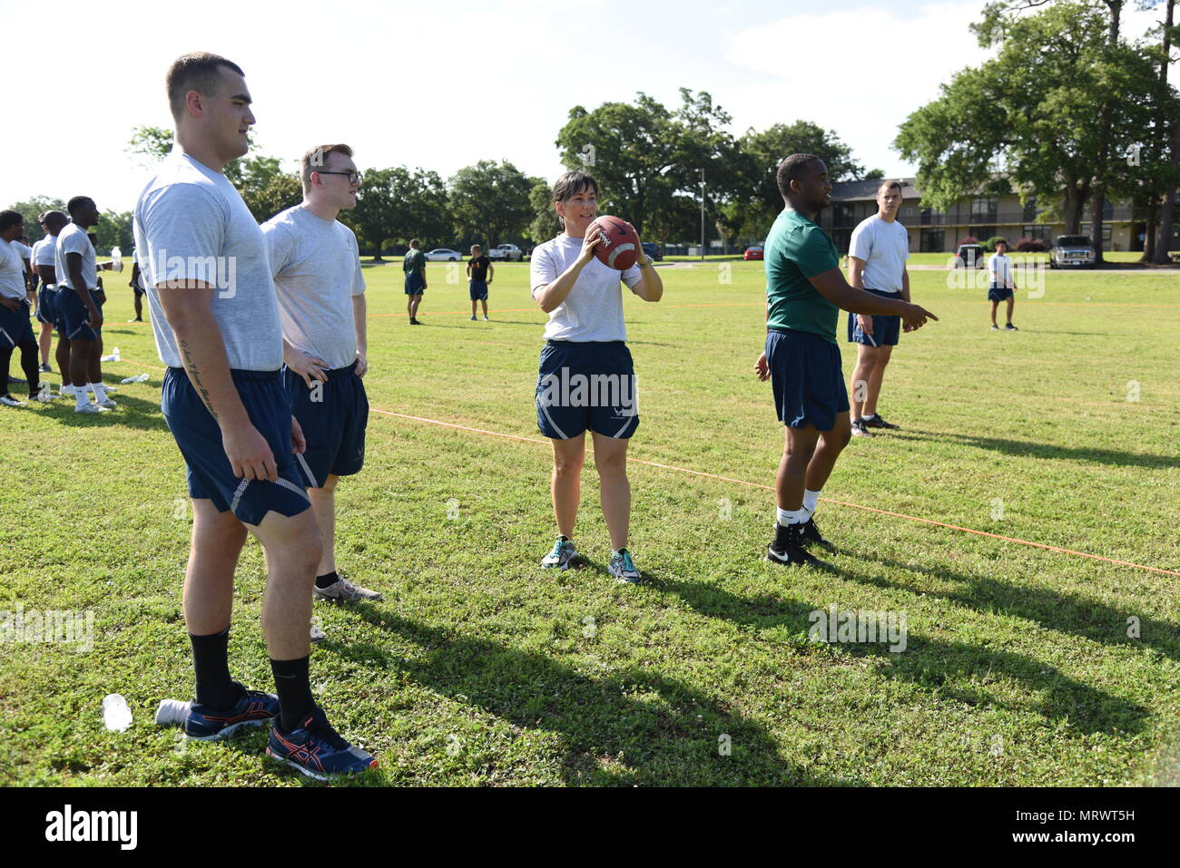 Col. Debra Lovette, 81st Training Wing commander, throws a football with Airmen from the 81st Medical Operations Squadron during field day events June 15, 2017, on Keesler Air Force Base, Miss. Field day was the final event of Wingman Week, which focused on the physical pillar of Comprehensive Airman Fitness, resiliency and teambuilding initiatives across the base. (U.S. Air Force photo by Kemberly Groue) Stock Photo