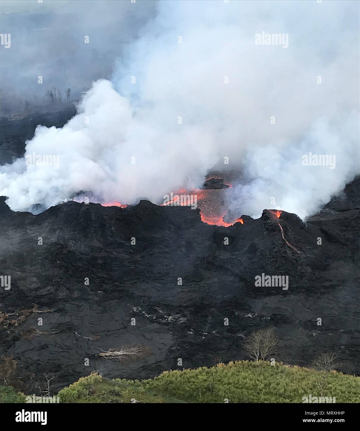 Lava and poisonous sulfur dioxide plumes rise as molten magma spews from fissure 22 from the eruption of the Kilauea volcano May 26, 2018 in Pahoa, Hawaii. Stock Photo