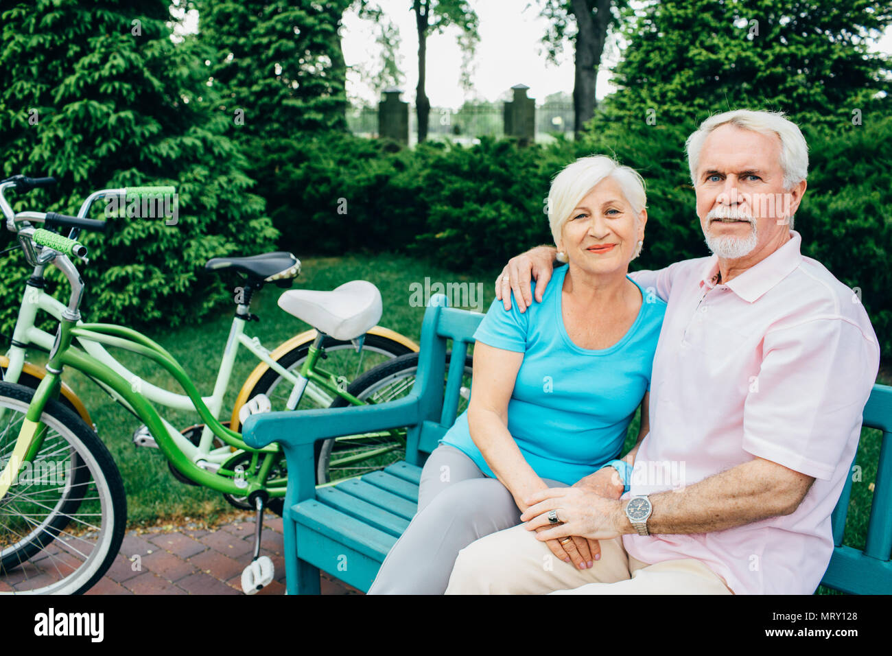 portrait of an elderly couple sitting in a city park Stock Photo