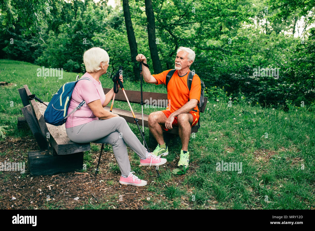 Senior couple hikers with poles resting Stock Photo