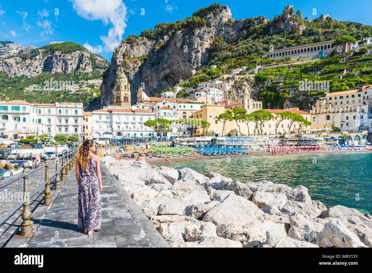 Amalfi, Amalfi coast, Salerno, Campania, Italy. Young woman strolling along the pier of Amalfi village Stock Photo