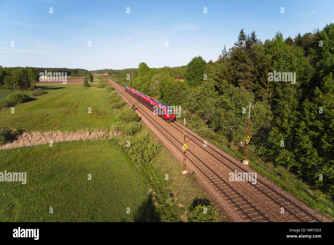 Molnbo, Sweden - May 25, 2018: Aerial view of a red electric MTR express train class X74 on double-track electrified railroad with destination Gothenb Stock Photo