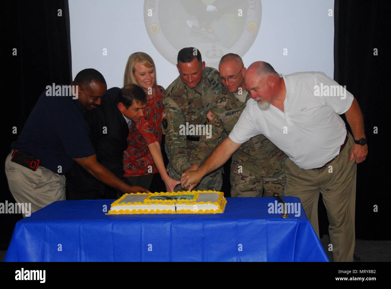 Brig. Gen. William E. King IV (center), commanding general of the 20th CBRNE Command from Aberdeen Proving Ground, Maryland, and Col. Thomas Holliday, Redstone Arsenal garrison commander, join special guests on July 10 to cut the cake that signifies the mission-ready status for the CARA-West team. This 37-member, highly specialized team completed a move this spring from Pinebluff Arsenal, Arkansas, to Redstone Arsenal next to Huntsville, Alabama. (20th CBRNE Command photo by Clem Gaines) Stock Photo