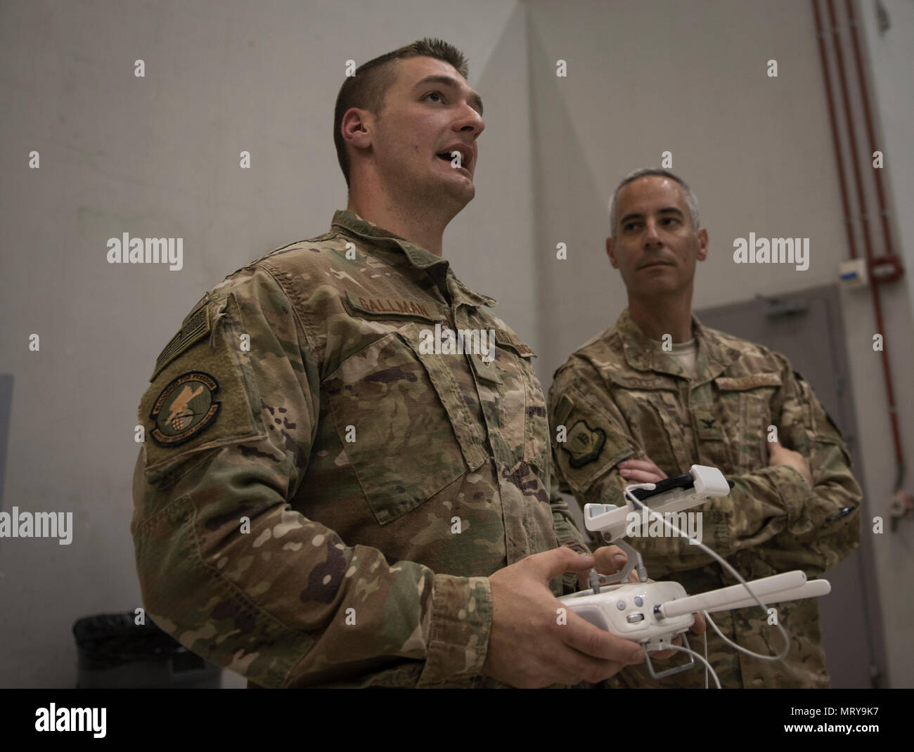 Senior Airman Christopher Gallman, 455th Expeditionary Security Forces Squadron joint defense operations center, speaks to Col. Bradford Coley, the 455th Expeditionary Mission Support Group commander, about the unmanned aircraft systems program during a live-demonstration at Bagram Airfield, Afghanistan, June 30, 2017. The 455th ESFS teamed up with a researcher from the Air Force Research Lab to teach Airmen how to pilot drones and use them to train coalition partners on how to react to them on the battlefield. (U.S. Air Force photo by Staff Sgt. Benjamin Gonsier) Stock Photo