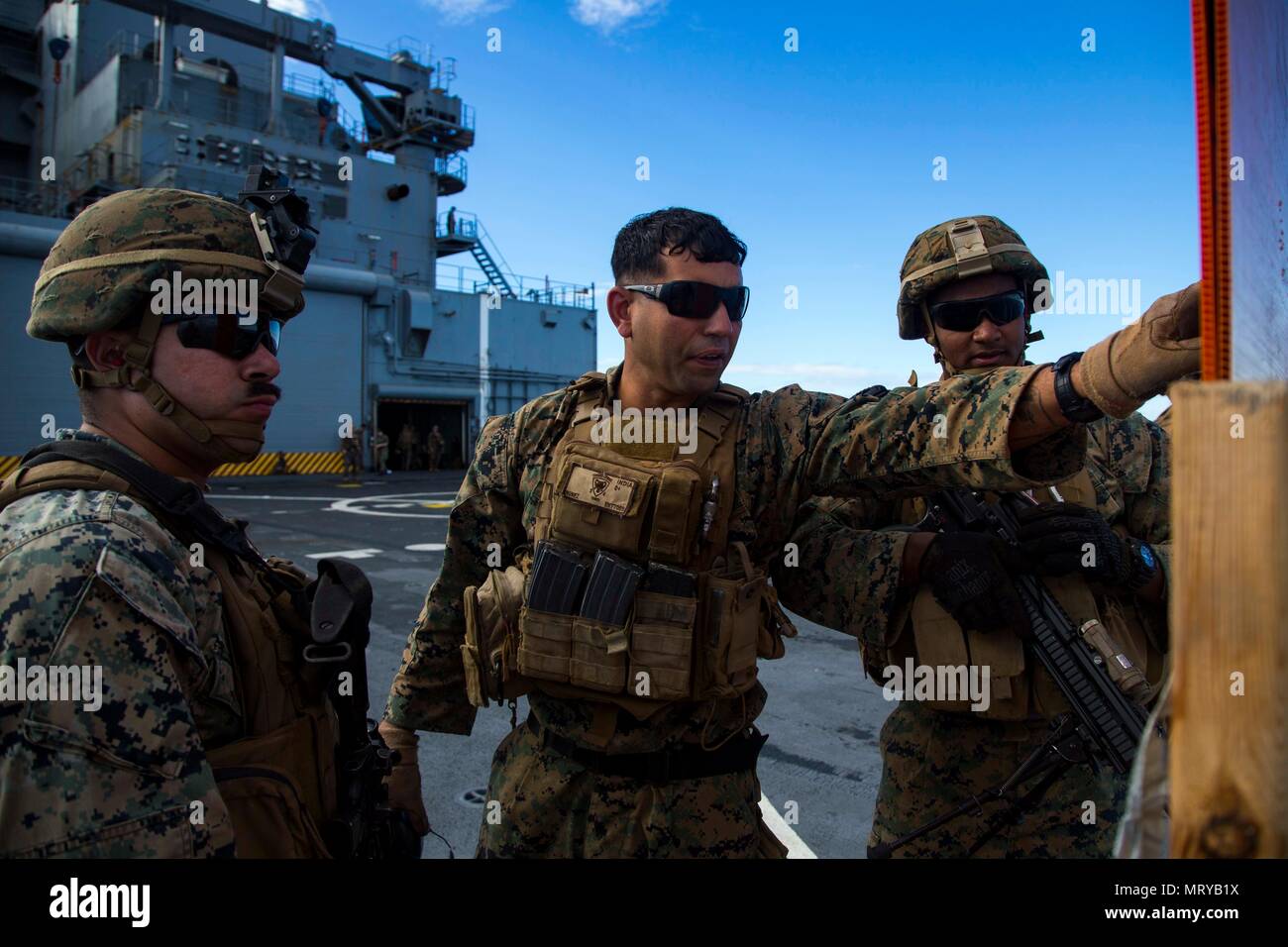U.S. Marine Corps Sgt. Elvis Nunez, an infantryman with Task Force Koa Moana 17, center, analyzes the shot groups of Marines during a live fire range aboard the USNS Sacagawea, July 13, 2017. Koa Moana 17 is designed to improve interoperability with our partners, enhance military-to-military relations, and expose the Marine Corps forces to different types of terrain for familiarity in the event of a natural disaster in the region.   (U.S. Marine Corps photo by MCIPAC Combat Camera Lance Cpl. Juan C. Bustos) Stock Photo