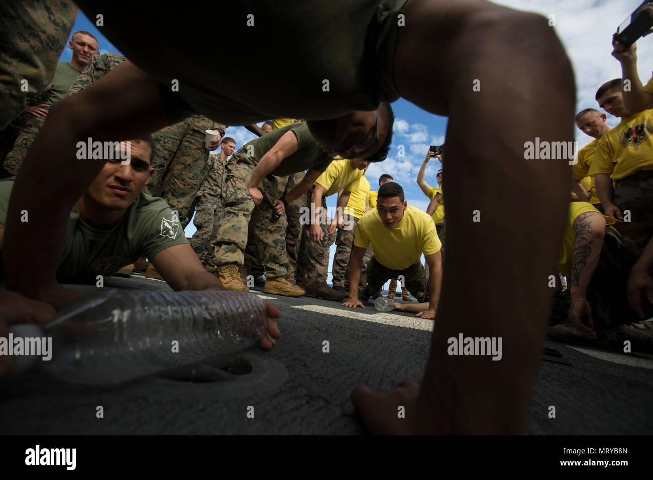 USNS SACAGAWEA— Lance Cpl. Juan Bustos competes in a pushup contest against French soldiers in celebration of Bastille Day July 14 aboard the USNS SACAGAWEA. Bastille Day is recognized as the day the French gained their independence from King Louis XVI by liberating prisoners from the Bastille Prison in 1789 and are now celebrating their 228th year as a free nation. Bustos is a combat photographer with III Marine Expeditionary Force, currently deployed to Koa Moana 17. (U.S. Marine Corps Photo by Sgt. Douglas D. Simons) Stock Photo