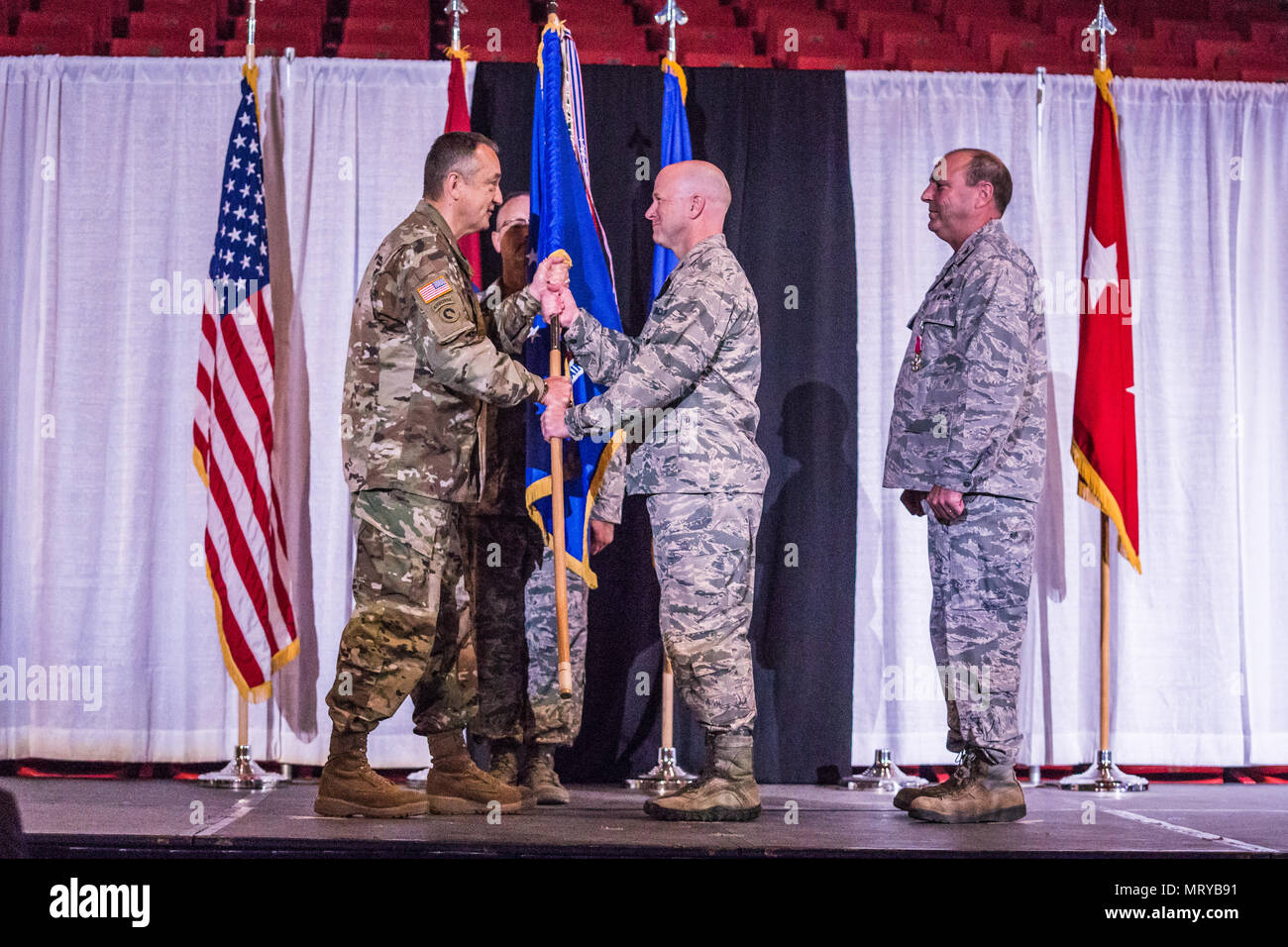 U.S. Air Force Col. Ed Black (center) takes command of the 139th Airlift Wing, Missouri Air National Guard, from Col. Ralph Schwader (right), during a change of command ceremony at the St. Joseph Civic Arena, St. Joseph, Mo. July 8, 2017. Passing the guidon is a formal process during a change of command ceremony signifying the transfer of leadership from one officer to another. Col. Schwader will be assigned to Missouri Air National Guard Headquarters in Jefferson City, after more than 3 years commanding the 139th. (U.S. Air National Guard photo by Staff Sgt. Patrick P. Evenson) Stock Photo