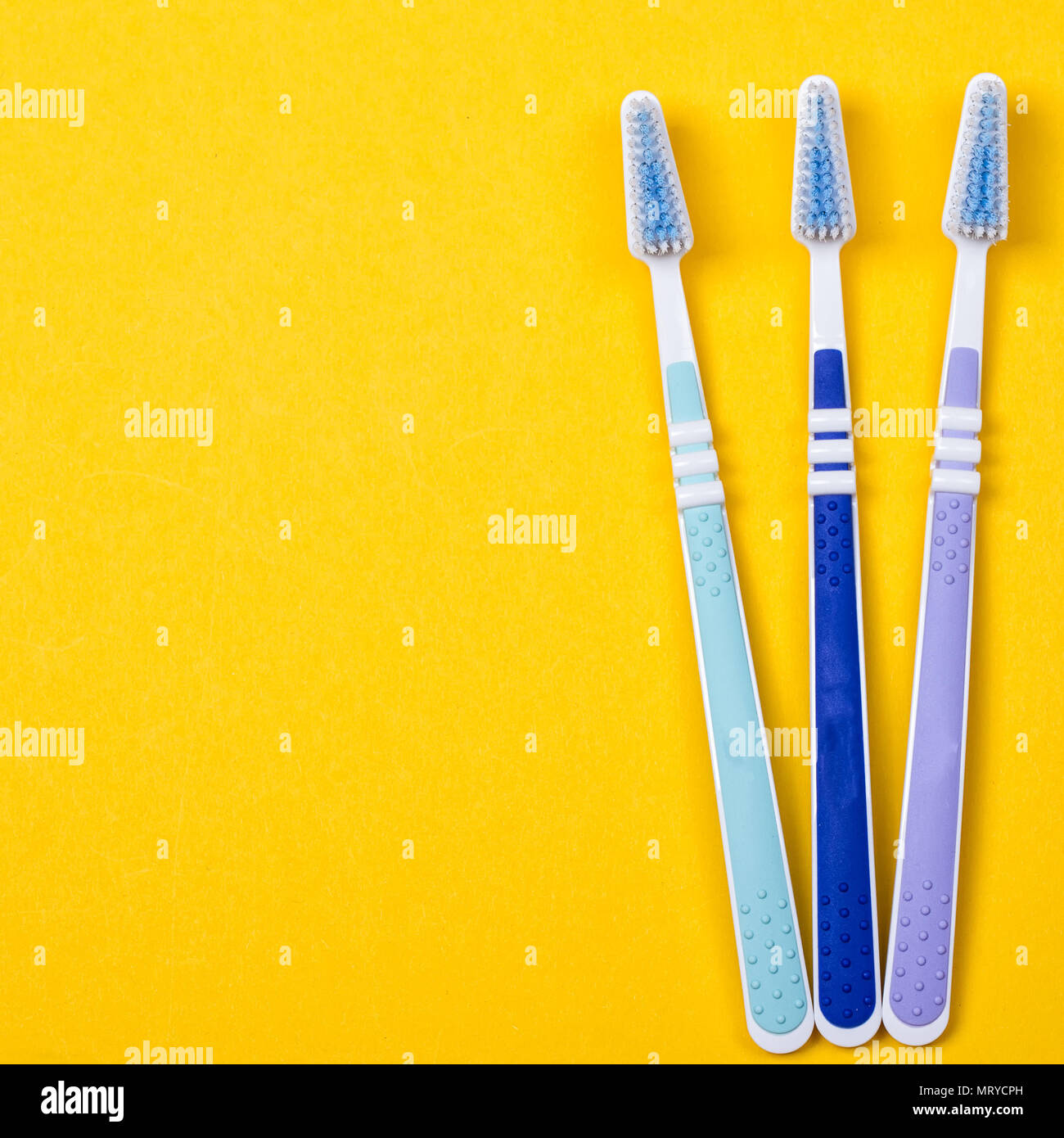 three Toothbrushes on the yellow background. Top view Stock Photo - Alamy