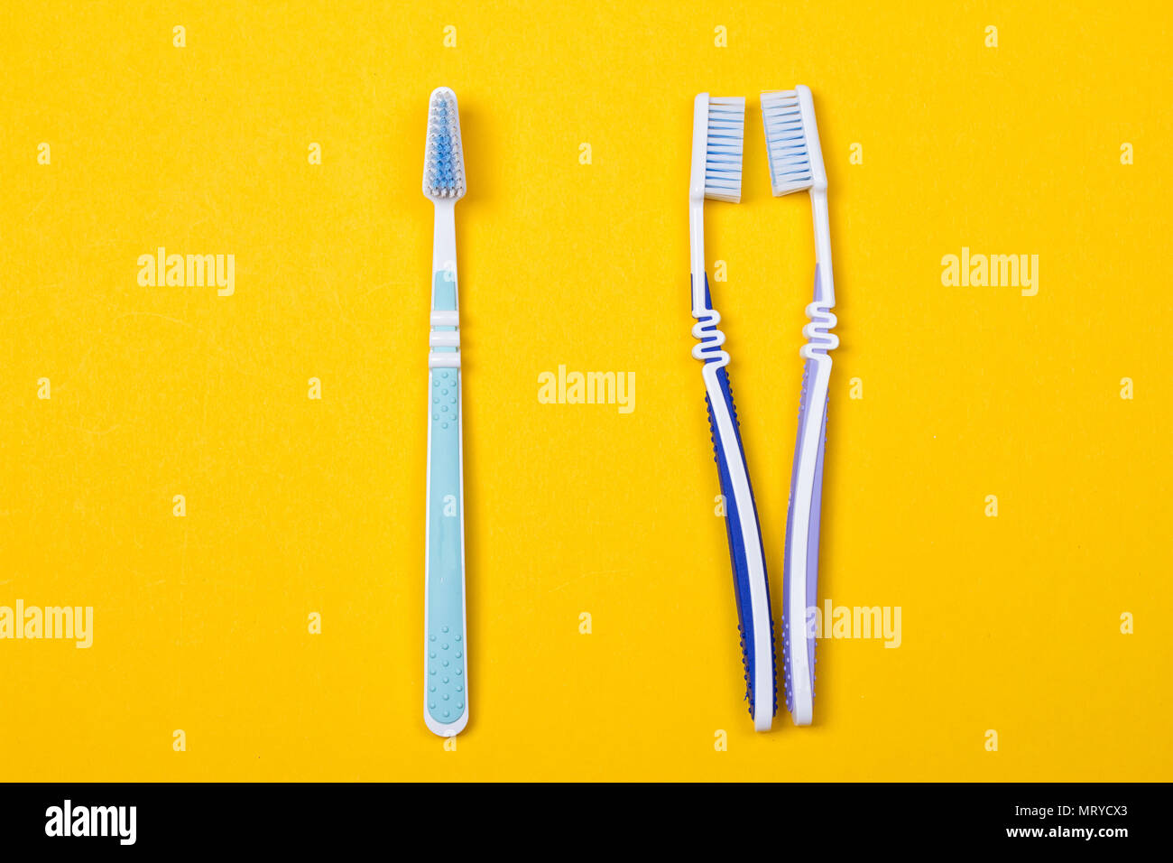 three Toothbrushes on the yellow background. Top view Stock Photo - Alamy