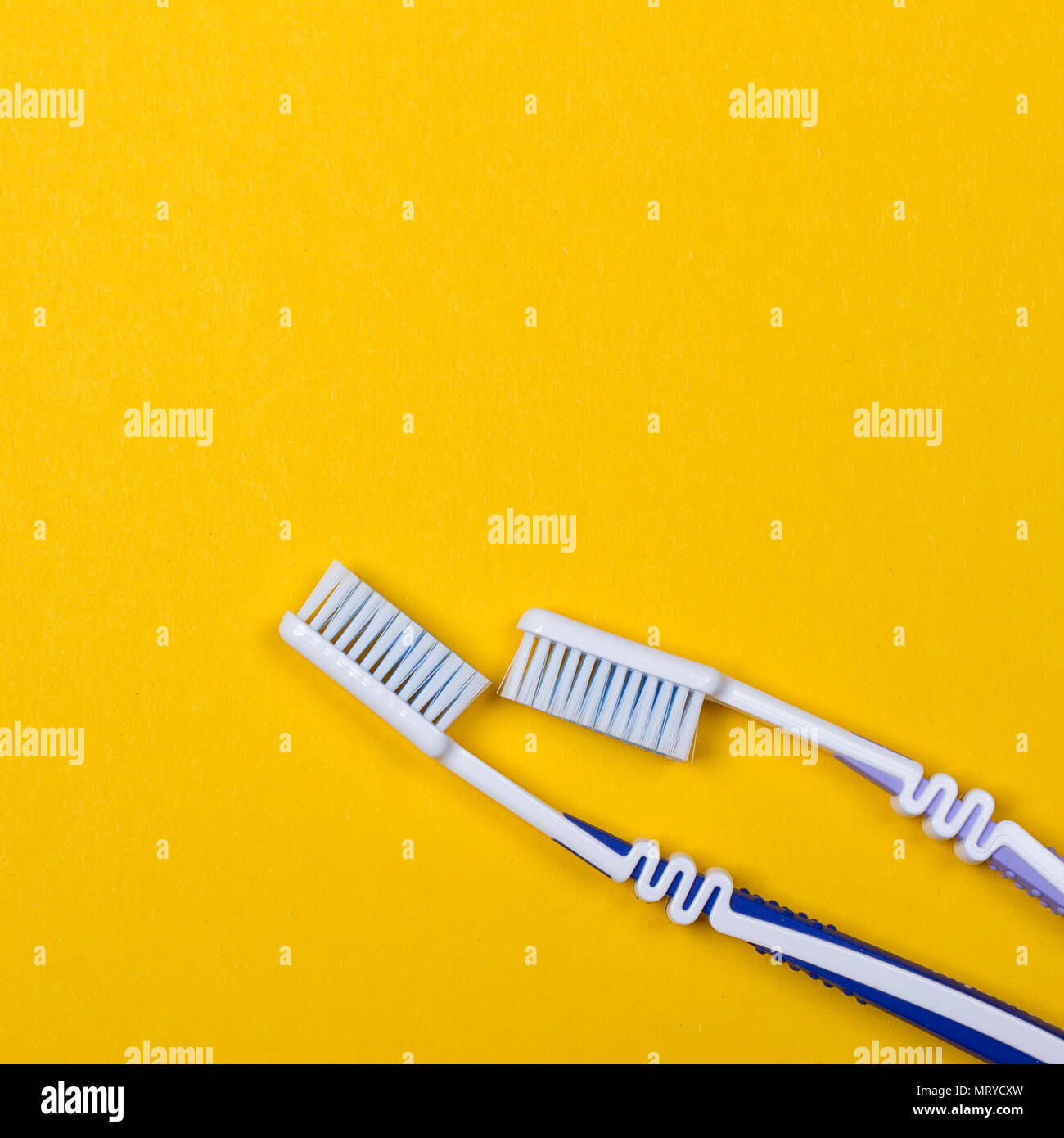 twi Toothbrushes on the yellow background. Top view Stock Photo - Alamy
