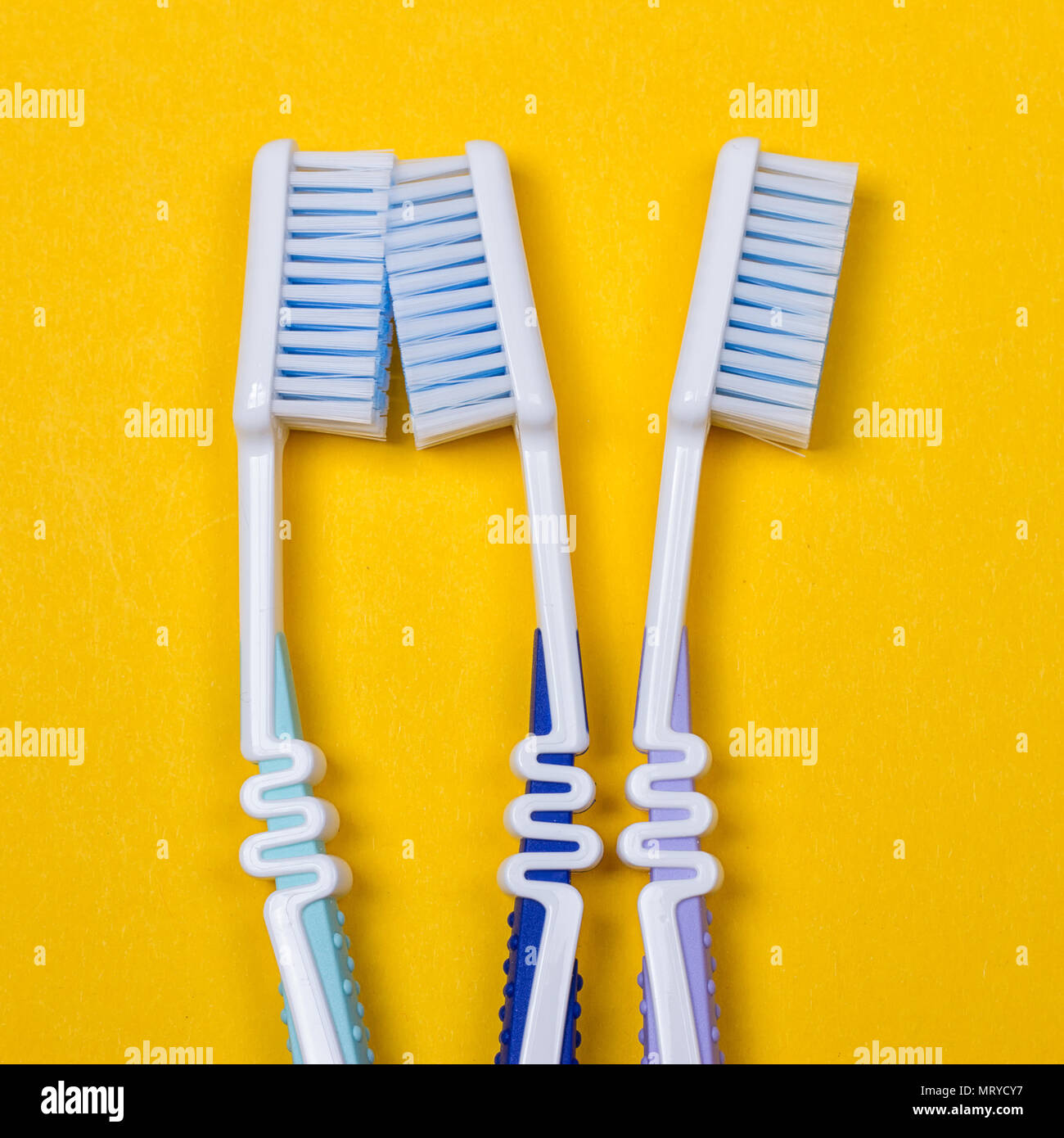 three Toothbrushes on the yellow background. Top view Stock Photo - Alamy