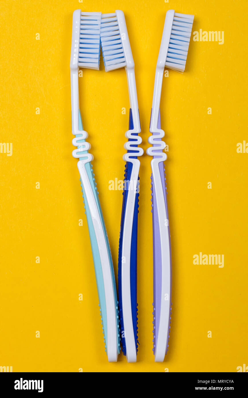 three Toothbrushes on the yellow background. Top view Stock Photo - Alamy
