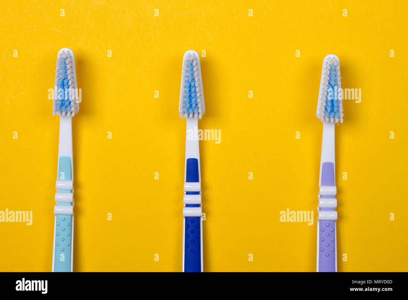 three Toothbrushes on the yellow background. Top view Stock Photo - Alamy