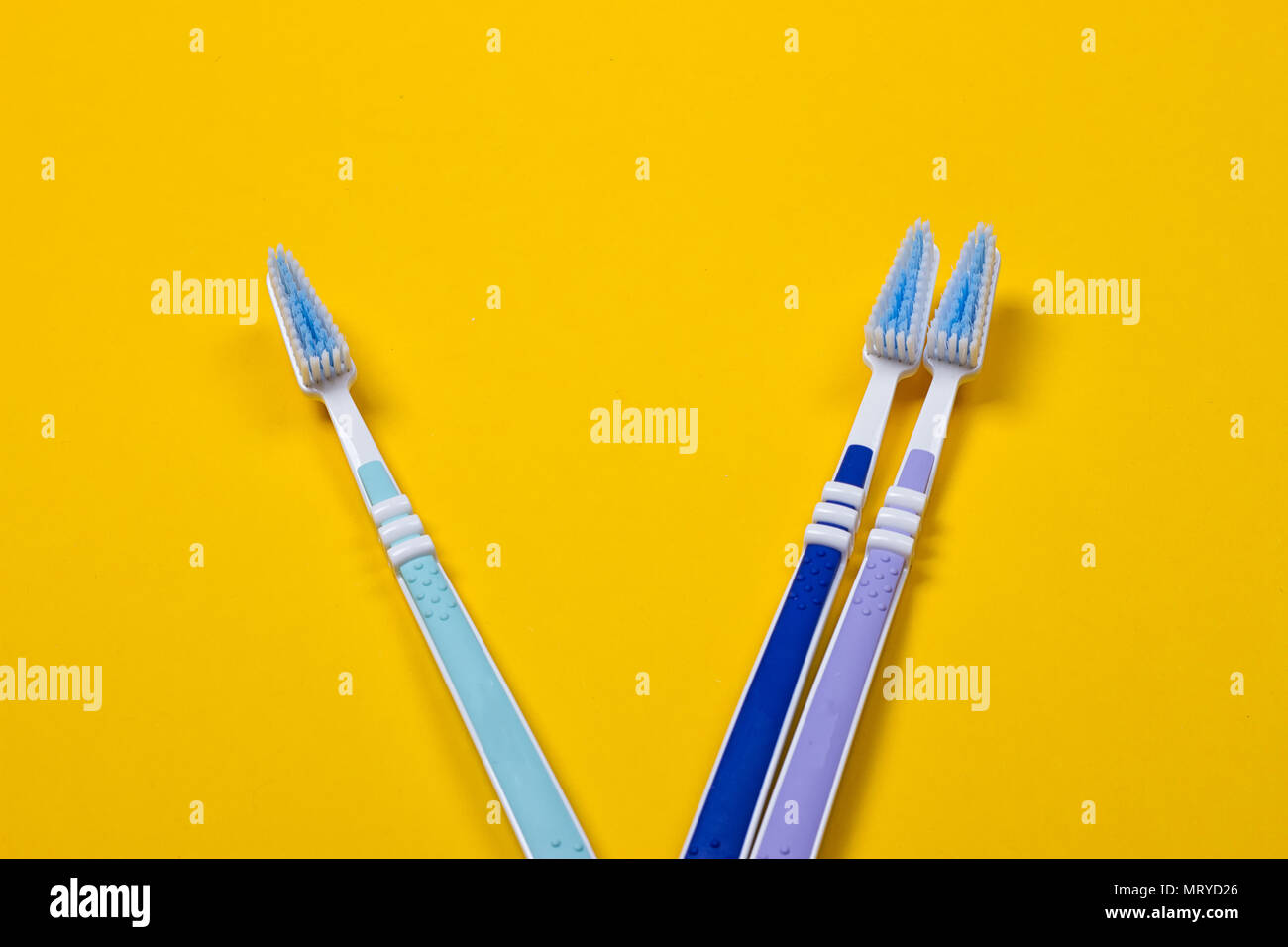three Toothbrushes on the yellow background. Top view Stock Photo - Alamy