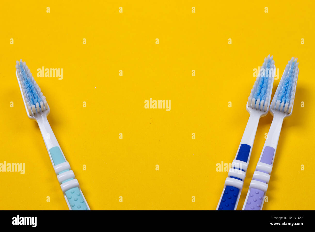three Toothbrushes on the yellow background. Top view Stock Photo - Alamy