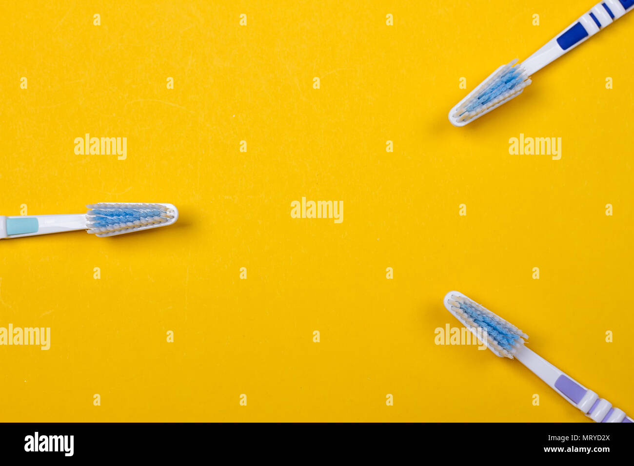 three Toothbrushes on the yellow background. Top view Stock Photo - Alamy