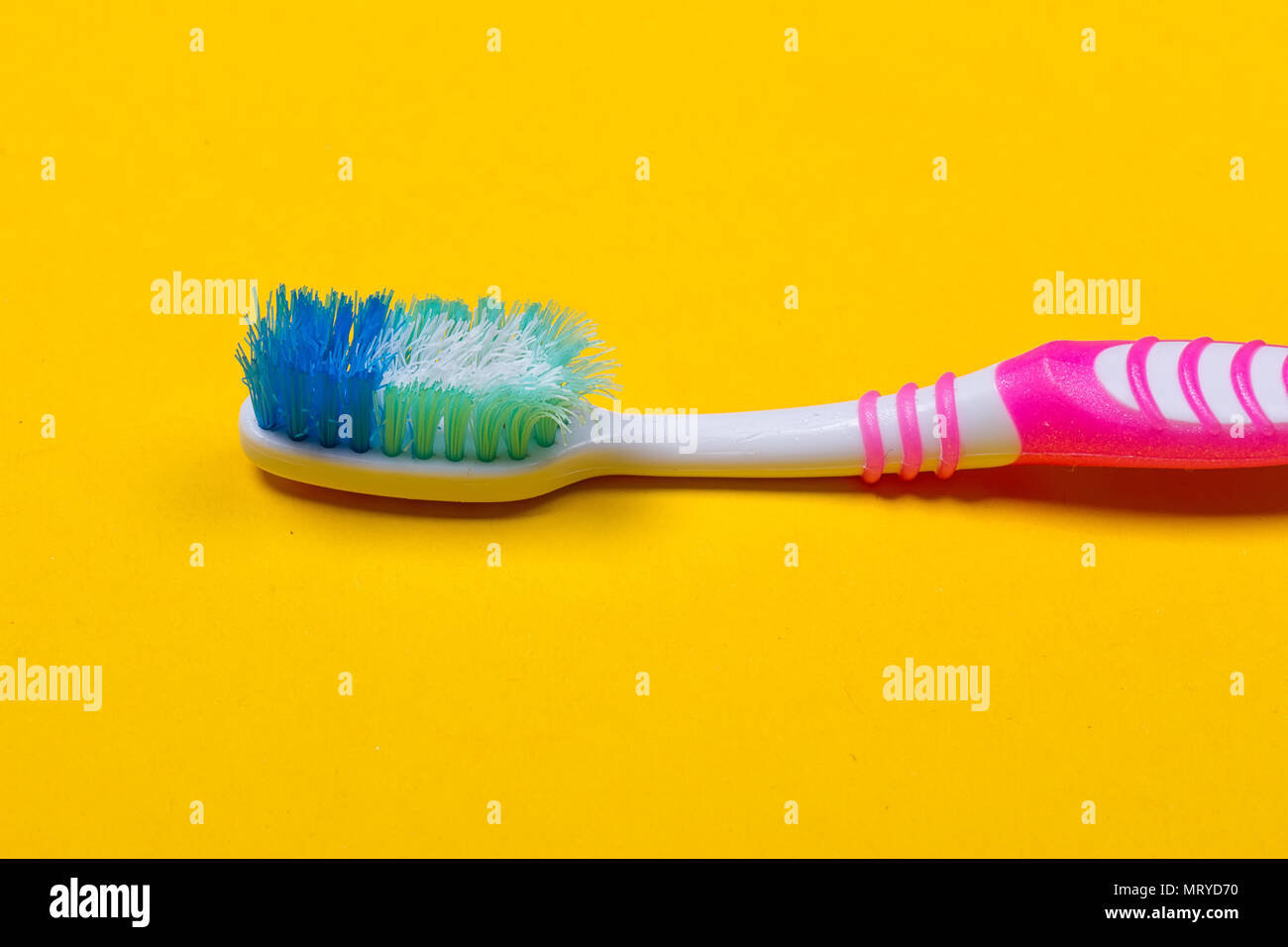 Old used toothbrush on the yellow background. Top view Stock Photo - Alamy