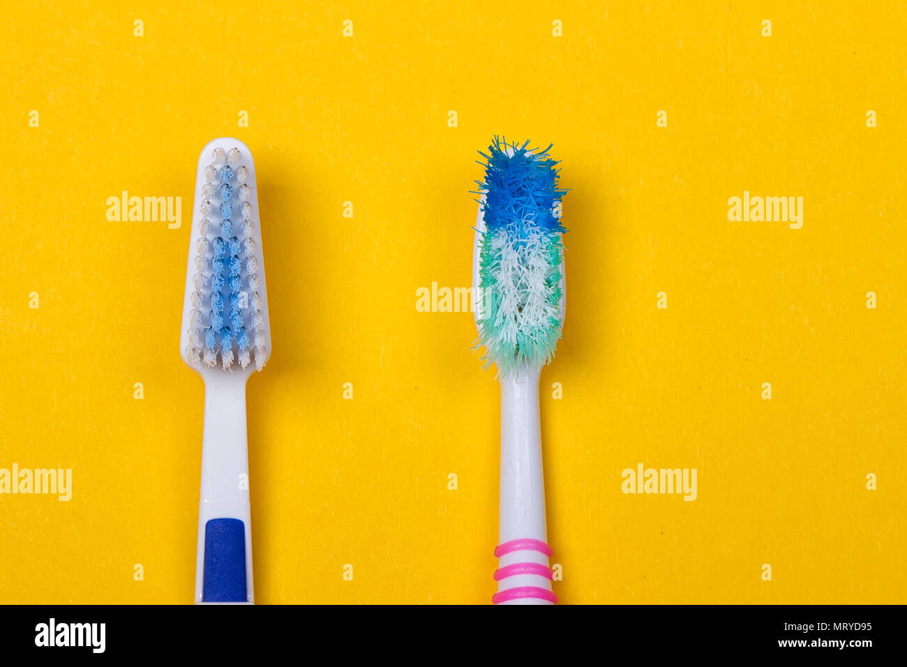 Old used and new toothbrushes on the yellow background. Top view Stock ...