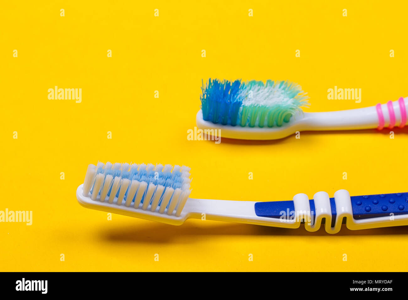 Old used and new toothbrushes on the yellow background. Top view Stock ...