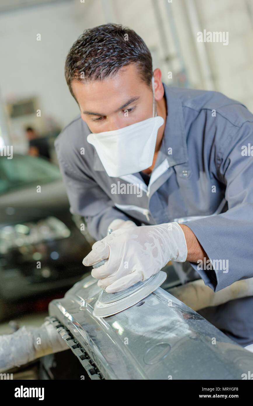 mechanic sanding car bumper Stock Photo Alamy